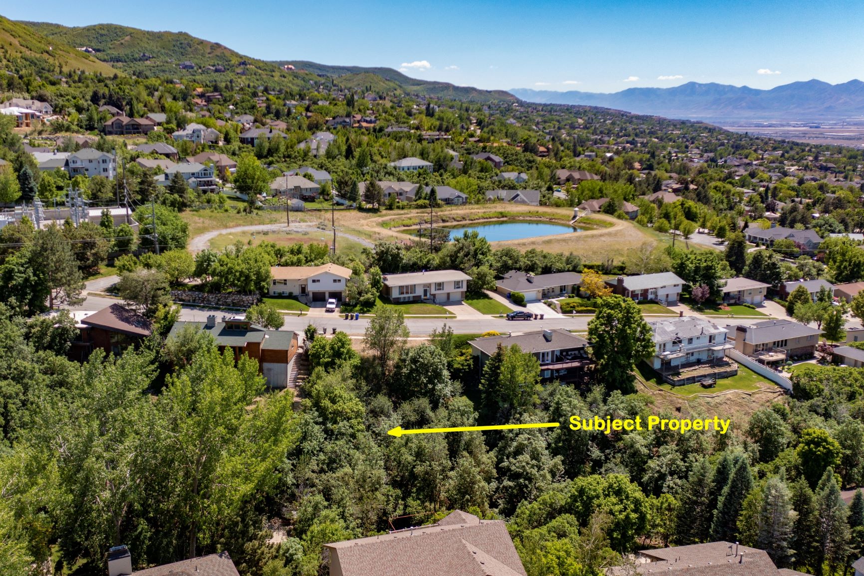 Aerial view of residential area featuring property boundaries highlighted and a water and mountain view