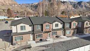 Traditional-style home featuring a residential view, roof with shingles, a mountain view, and brick siding