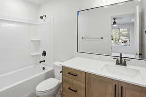 Full bathroom featuring vanity, shower / washtub combination, and a ceiling fan