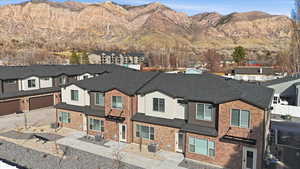 View of front of home with a residential view, a mountain view, and roof with shingles