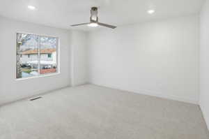 Empty room featuring light carpet, recessed lighting, and a ceiling fan