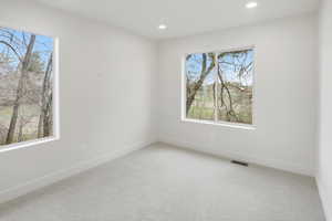 Empty room featuring light colored carpet and recessed lighting