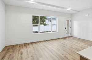 Spare room with light wood-style flooring and baseboards