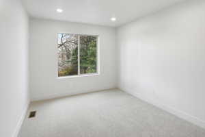 Spare room featuring light carpet and recessed lighting
