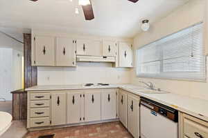 Kitchen with light countertops, white appliances, a ceiling fan, and cream cabinets