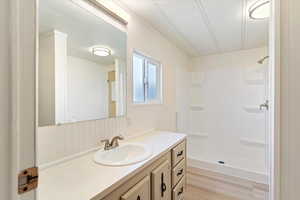 Bathroom featuring vanity, a shower stall, and light wood-style floors