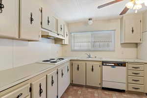 Kitchen with light countertops, white appliances, cream cabinets, a ceiling fan, and a textured ceiling