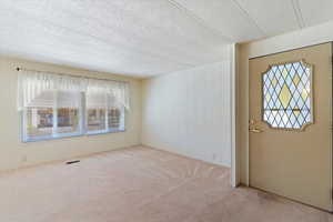 Carpeted entrance foyer featuring wooden walls