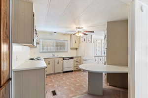 Kitchen featuring cream cabinetry, light countertops, white appliances, a textured ceiling, and ceiling fan