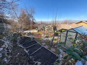 View of yard featuring an outbuilding, an exterior structure, and a garden
