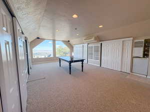 Recreation room with a textured ceiling, light carpet, and recessed lighting.  Loft above detached garage