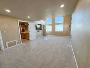 Unfurnished main bedroom featuring a textured ceiling, recessed lighting, and light carpet with view of valley and lake