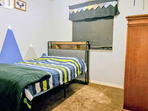 Bedroom with baseboards and light carpet