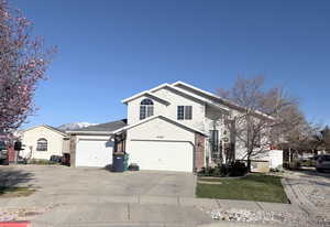 View of front of home featuring brick siding, driveway, and an attached garage
