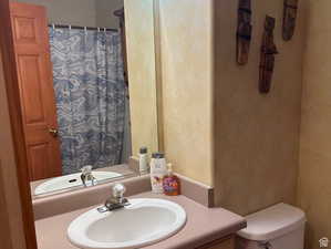 Full bathroom featuring vanity, a textured wall, and a shower with shower curtain