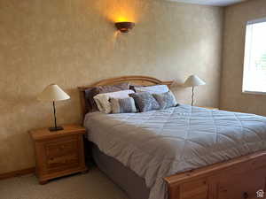 Bedroom featuring wallpapered walls and carpet