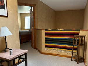 Bedroom featuring a textured wall and light carpet
