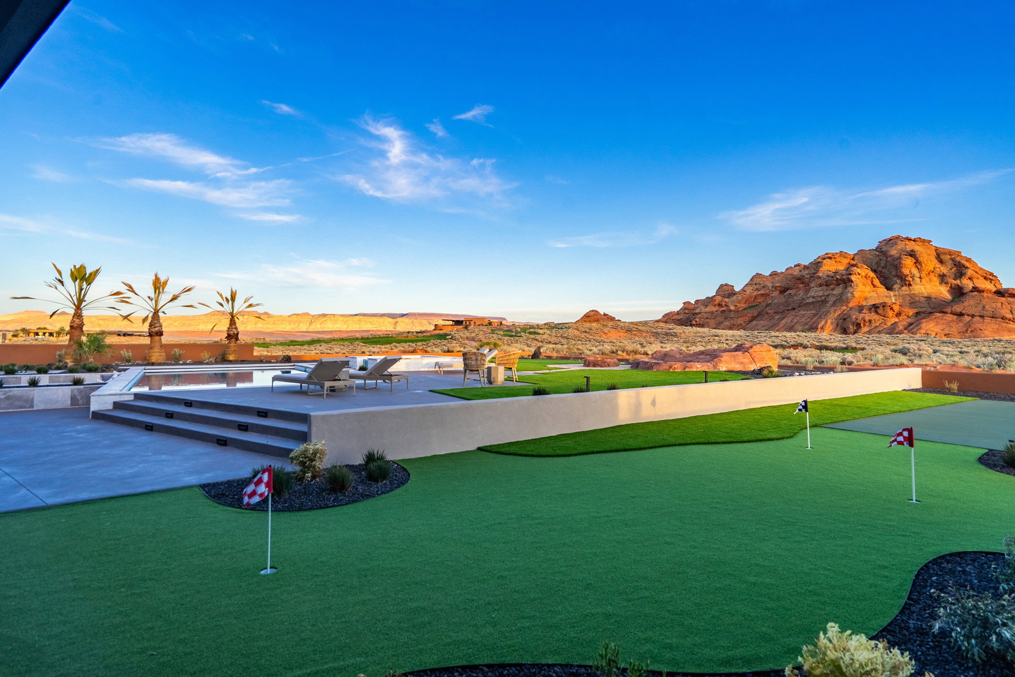 Surrounding community featuring a putting green, a mountain view, and a patio area