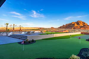 Surrounding community featuring a putting green, a mountain view, and a patio area