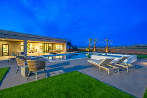 Swimming pool featuring a patio area, a hot tub, a yard, and outdoor dining space