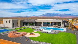 Back of house with an outdoor fire pit, a mountain view, a patio area, stone siding, and stucco siding