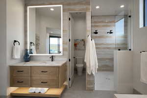 Bathroom featuring vanity, recessed lighting, a walk in shower, and tile walls
