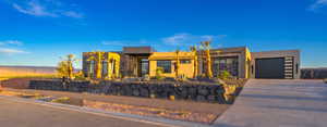 Contemporary house with stucco siding, a garage, and driveway