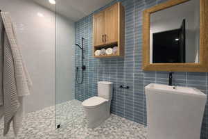Bathroom with tile walls, walk in shower, tile patterned floors, and recessed lighting
