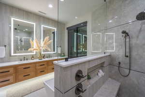 Full bathroom featuring double vanity, a tile shower, a soaking tub, and recessed lighting