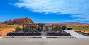 View of front of house featuring a mountain view, concrete driveway, and stucco siding