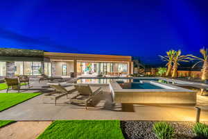 Pool at twilight featuring a patio and a pool with connected hot tub