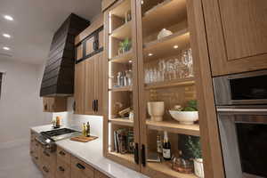 Bar area with stainless steel appliances, light stone counters, recessed lighting, and light wood finish cabinets