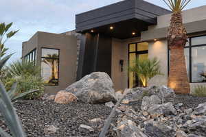 Doorway to property featuring stucco siding