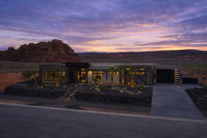 Contemporary house featuring concrete driveway, a garage, a mountain view, covered porch, and stucco siding