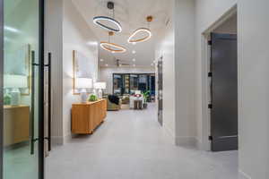 Hallway with recessed lighting and a high ceiling