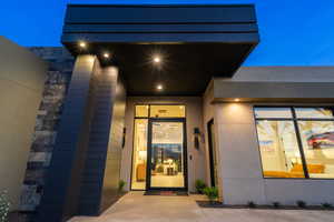 Exterior entry at twilight featuring stucco siding