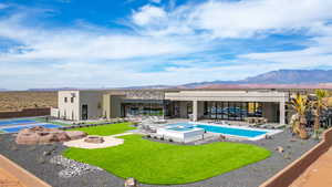Rear view of property featuring a patio, a mountain view, a fire pit, a tennis court, and stucco siding
