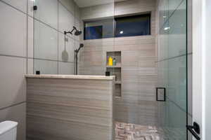 Bathroom with a stall shower and tile walls
