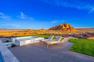 View of patio / terrace with a mountain view, a pool with connected hot tub, and view of desert landscape
