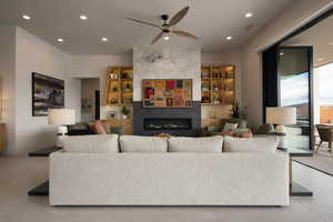Living room featuring a ceiling fan, a tiled fireplace, and recessed lighting