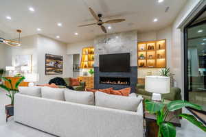 Living room featuring a ceiling fan, recessed lighting, built in features, and a fireplace