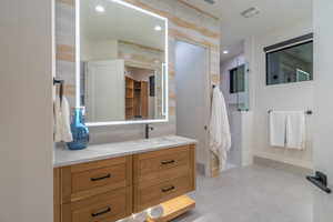 Full bath with vanity and tasteful backsplash