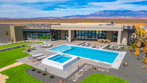 Relaxing pool / spa featuring a patio, a mountain view, and outdoor dining space