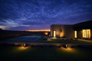 View of front of house with a tennis court, stucco siding, a mountain view, and stone siding