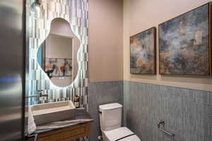 Half bathroom featuring vanity and a wainscoted wall