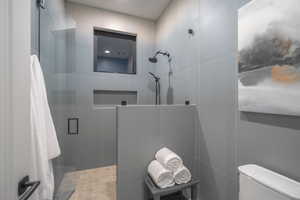 Bathroom with a shower stall and toilet