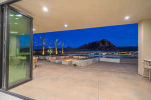 Patio at twilight featuring a fire pit and a mountain view