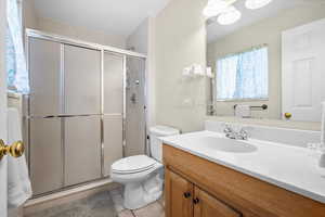 Full bath with vanity, a stall shower, and light tile patterned flooring