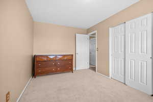 Bedroom featuring light carpet and a closet