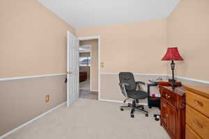 Home office featuring light colored carpet and baseboards